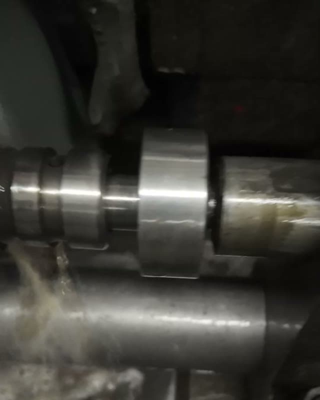 The camshaft grinder grinding the profile under coolant
